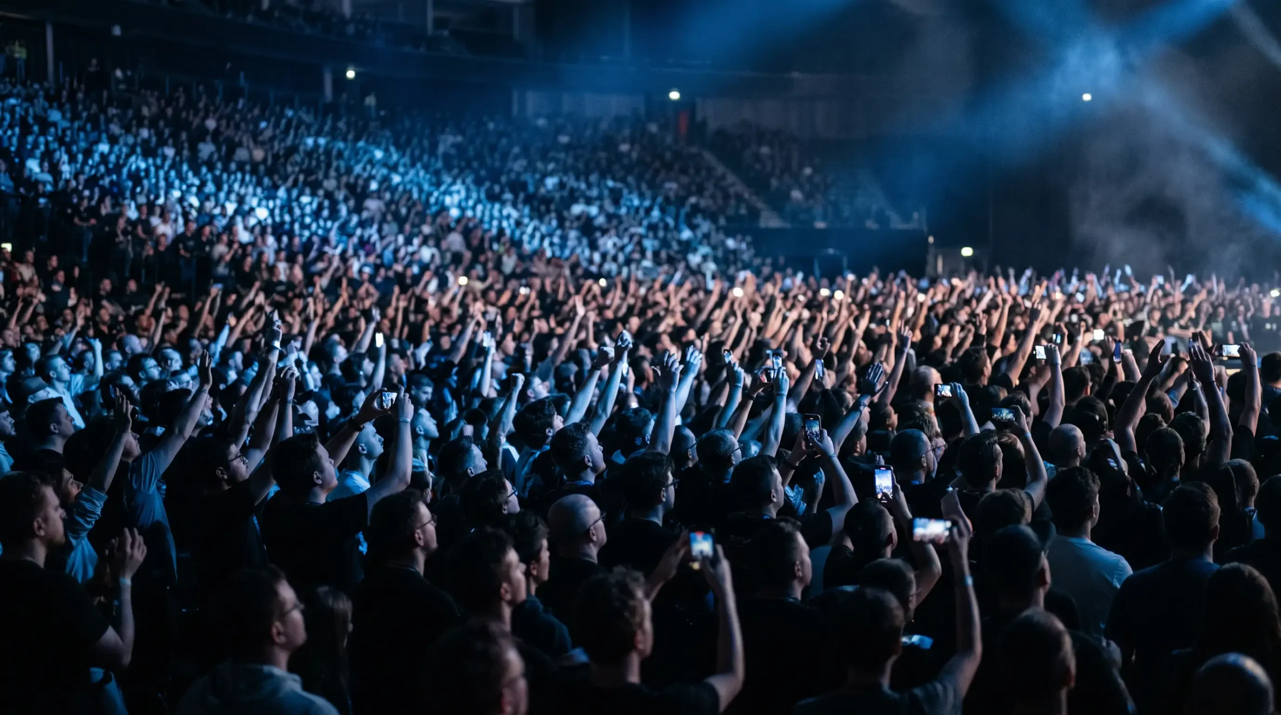 Multitud de espectadores llenando un estadio durante la gran final de un torneo internacional de esports con luces azuladas